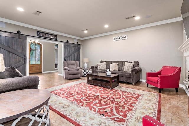 living room featuring crown molding, baseboards, visible vents, and a barn door