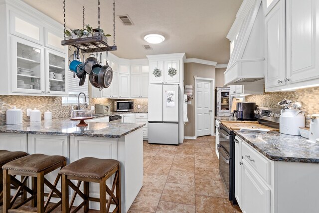 kitchen with custom range hood, a sink, a peninsula, stainless steel appliances, and white cabinetry
