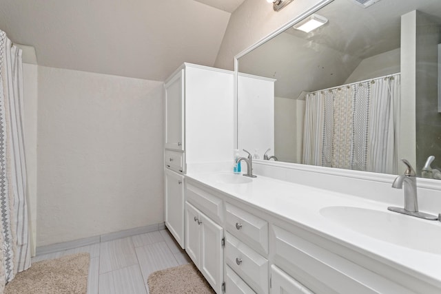 bathroom featuring a sink, a shower with curtain, double vanity, and lofted ceiling
