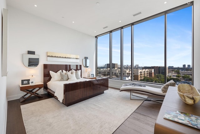 2323 W Main St Unit 703, Houston, TX 77098 - bedroom with baseboards, a city view, visible vents, and wood finished floors