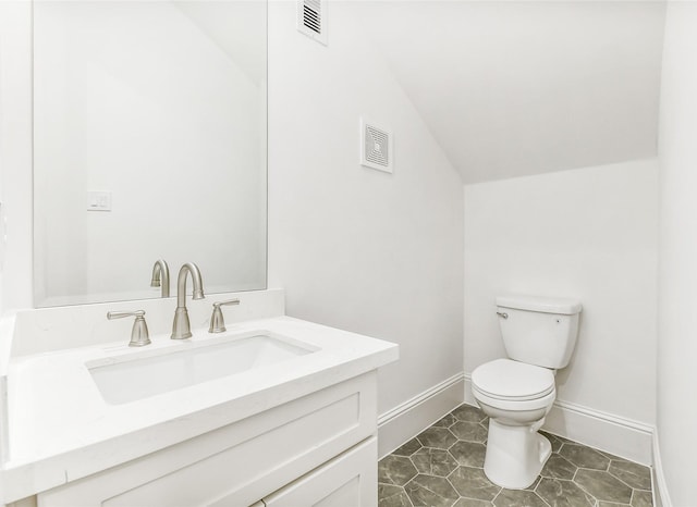 half bathroom featuring vanity, toilet, baseboards, lofted ceiling, and visible vents