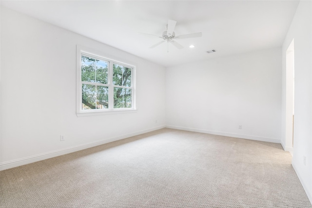 spare room with a ceiling fan, light colored carpet, visible vents, baseboards, and recessed lighting