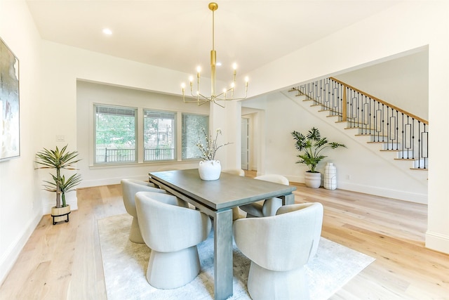 dining space with stairway, baseboards, light wood-type flooring, and a notable chandelier