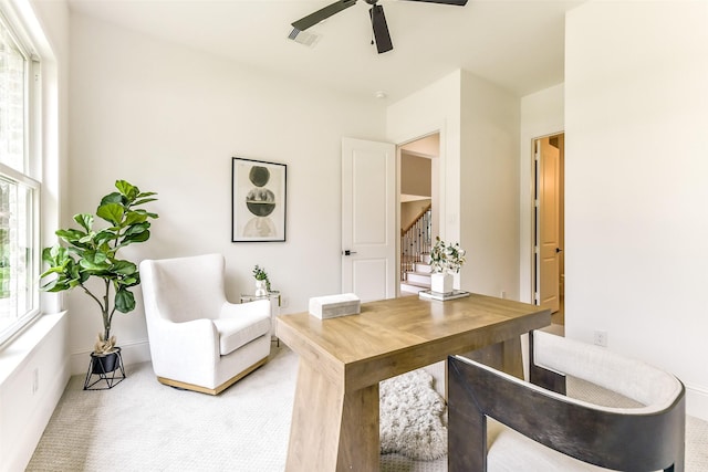 carpeted home office with ceiling fan and visible vents