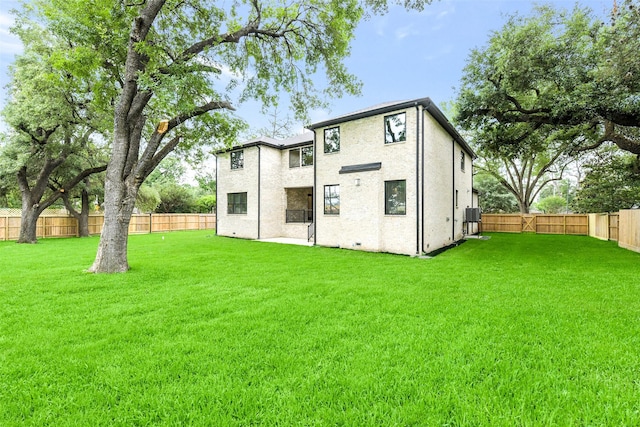 back of house featuring a lawn and a fenced backyard