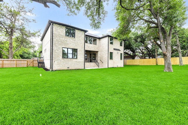 back of house with a yard and a fenced backyard