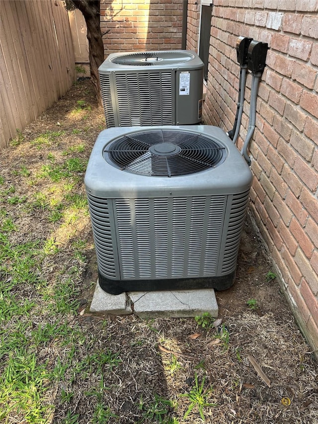 details featuring central AC unit and brick siding