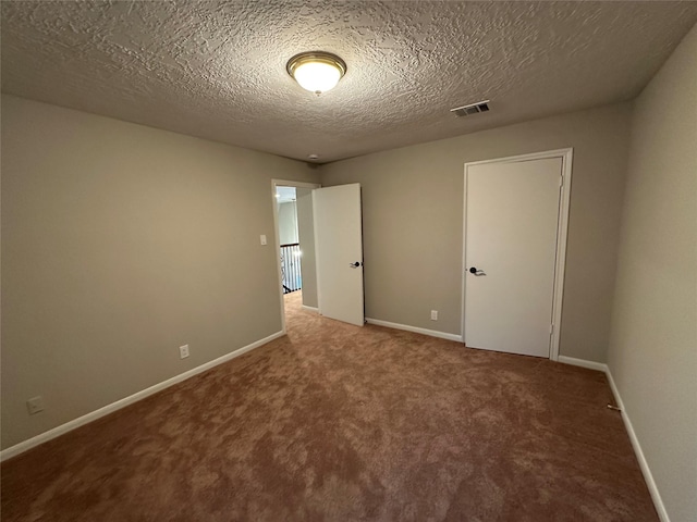 unfurnished bedroom featuring carpet flooring, a textured ceiling, baseboards, and visible vents