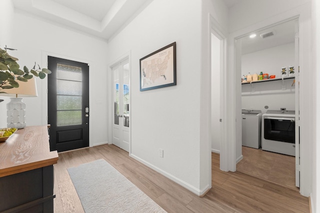 entrance foyer featuring baseboards, washing machine and dryer, light wood-type flooring, and visible vents