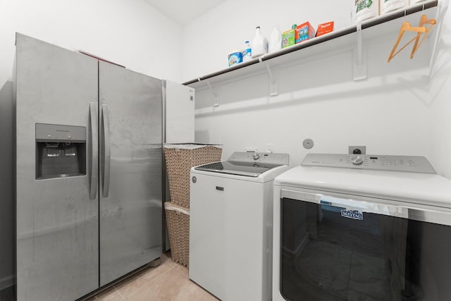 laundry area featuring washer and dryer, light tile patterned flooring, and laundry area