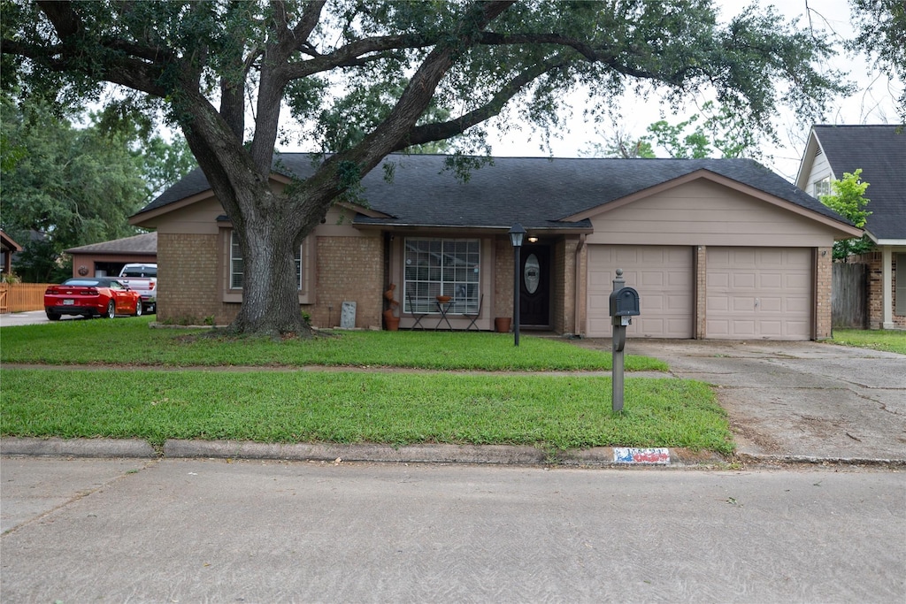ranch-style home with concrete driveway, brick siding, an attached garage, and a front yard