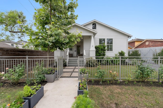 bungalow-style house with a porch, a garden, and fence private yard