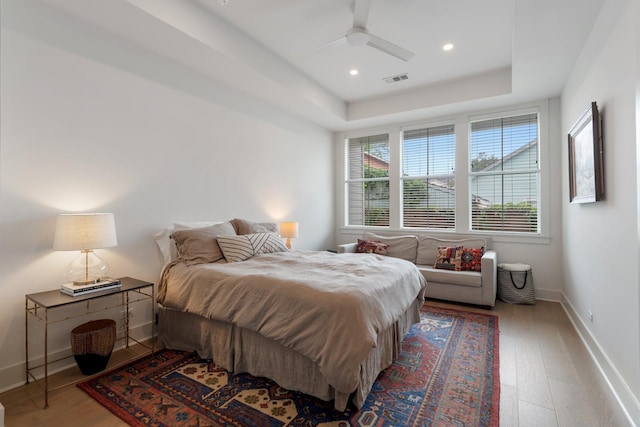 bedroom with a ceiling fan, baseboards, recessed lighting, wood finished floors, and visible vents