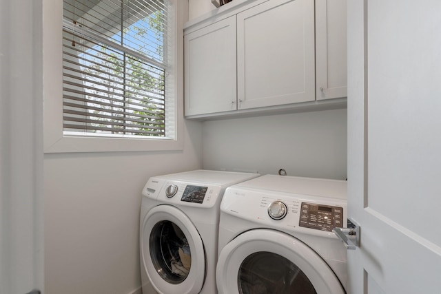 washroom featuring separate washer and dryer and cabinet space