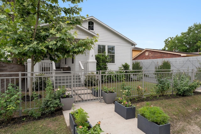 bungalow-style house with a fenced front yard and a gate