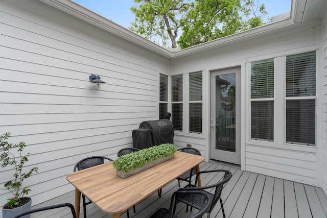 deck featuring outdoor dining area and grilling area