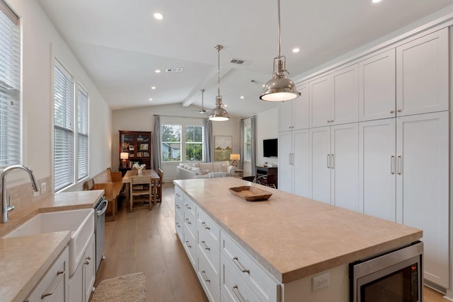 kitchen with visible vents, appliances with stainless steel finishes, light wood-type flooring, lofted ceiling with beams, and recessed lighting