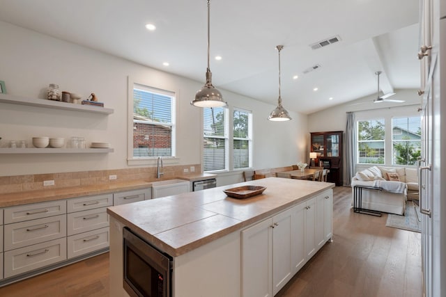kitchen featuring a kitchen island, stainless steel appliances, visible vents, and a wealth of natural light