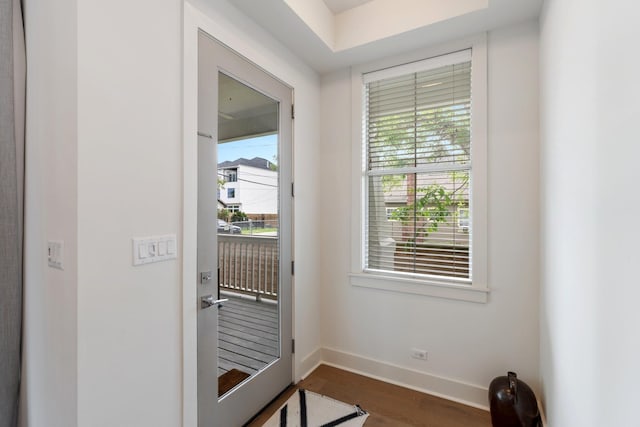 entryway featuring baseboards and dark wood-style floors