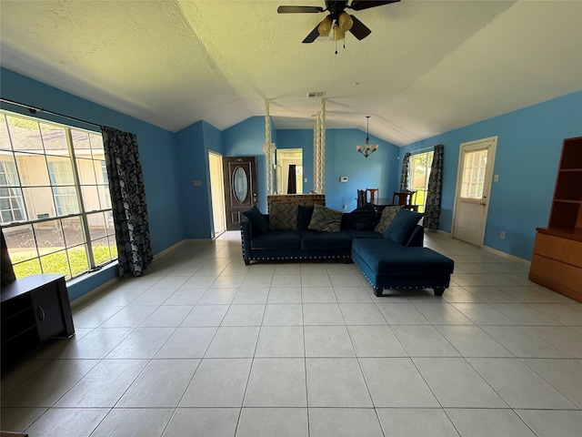 710 Fawnwood Dr, Missouri City, TX 77489 - living area with light tile patterned floors, a wealth of natural light, ceiling fan with notable chandelier, and lofted ceiling
