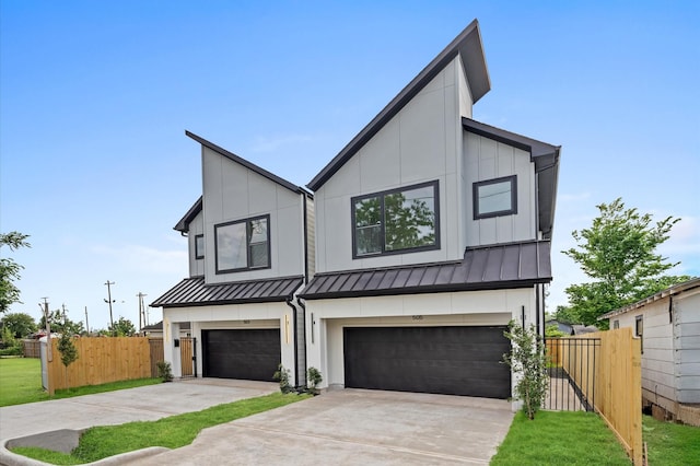 view of front facade featuring an attached garage, concrete driveway, fence, and a standing seam roof