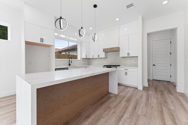 kitchen with a sink, decorative backsplash, modern cabinets, and white cabinetry