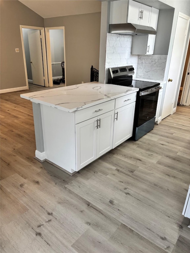 kitchen with white cabinets, stainless steel range with electric cooktop, light stone countertops, light wood-style flooring, and backsplash