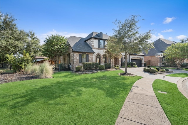 french country home with stone siding, driveway, a front lawn, and brick siding