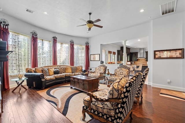 living room featuring a ceiling fan, visible vents, and dark wood finished floors