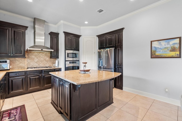 kitchen with a kitchen island, light stone countertops, wall chimney exhaust hood, light tile patterned floors, and stainless steel appliances