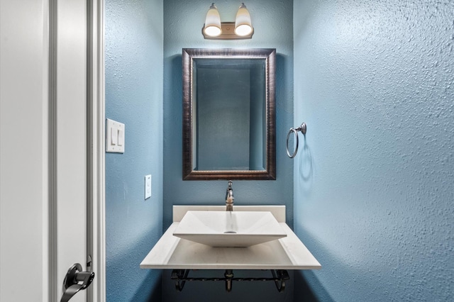 bathroom with a textured wall and a sink