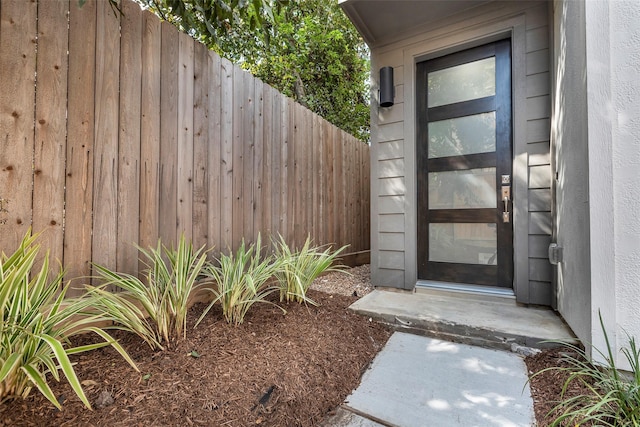 doorway to property featuring fence