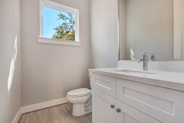 bathroom with baseboards, toilet, and vanity