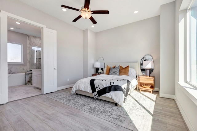 bedroom with recessed lighting, connected bathroom, and light wood-style flooring