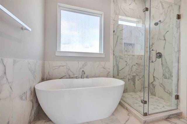 full bath featuring a freestanding tub, a marble finish shower, tile walls, and marble finish floor
