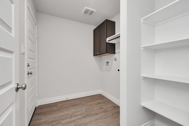10310 Woodhill Spa Ln, Cleveland, TX 77327 - washroom featuring hookup for an electric dryer, hookup for a washing machine, wood finished floors, cabinet space, and baseboards