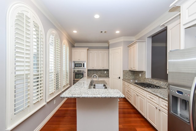 kitchen featuring a sink, appliances with stainless steel finishes, backsplash, and dark wood-style floors