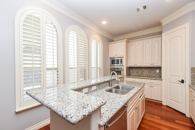 kitchen with visible vents, ornamental molding, a sink, dark wood finished floors, and appliances with stainless steel finishes