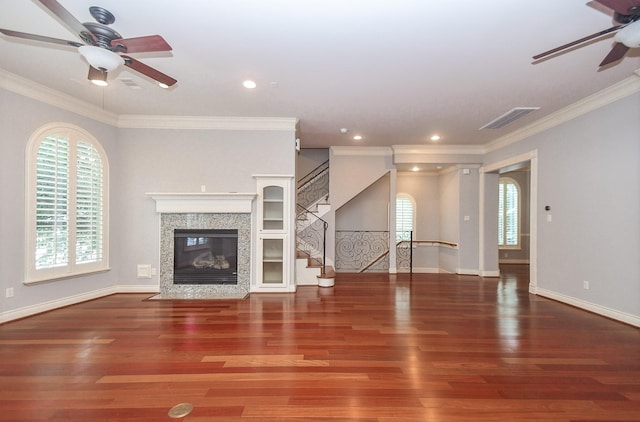 unfurnished living room with a healthy amount of sunlight, ceiling fan, stairway, and wood finished floors