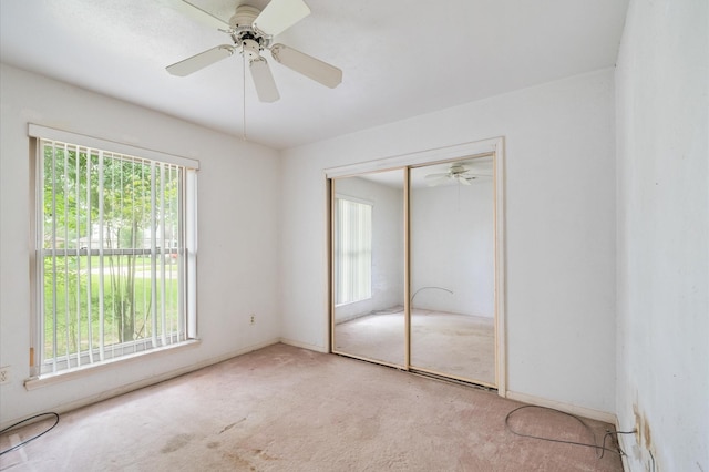 unfurnished bedroom with a closet, carpet flooring, and ceiling fan