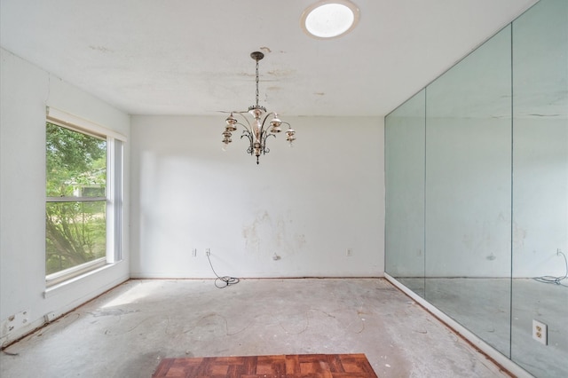 unfurnished room with a chandelier