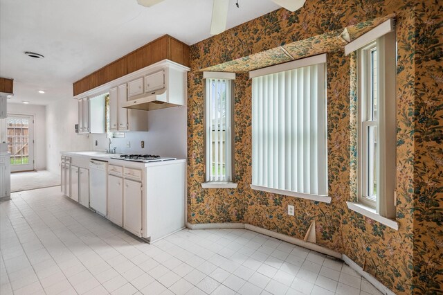 kitchen featuring light countertops, baseboards, a wealth of natural light, and dishwasher