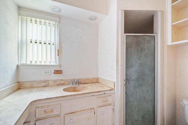 full bathroom with vanity, a shower stall, and toilet