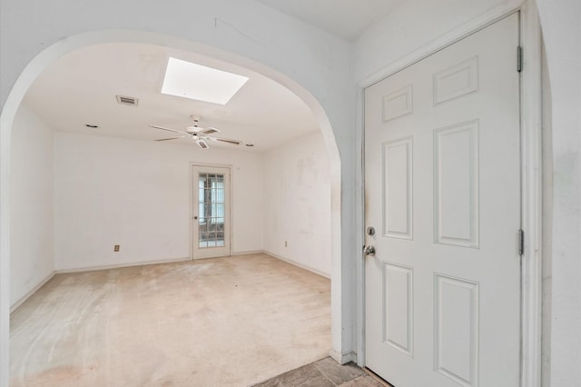 entrance foyer featuring light colored carpet, arched walkways, a ceiling fan, baseboards, and visible vents