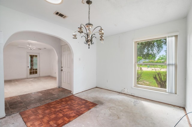 unfurnished room with arched walkways, ceiling fan with notable chandelier, and visible vents