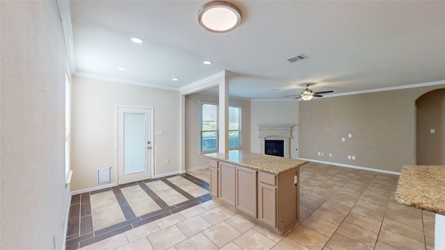 kitchen featuring crown molding, a fireplace, a ceiling fan, and visible vents