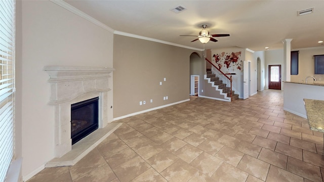 unfurnished living room featuring baseboards, ceiling fan, a premium fireplace, and visible vents