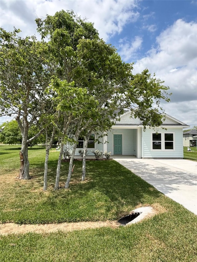view of front of property with concrete driveway and a front yard