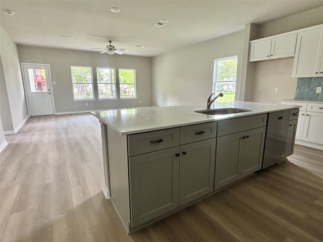 kitchen featuring a sink, white cabinets, and light wood-type flooring