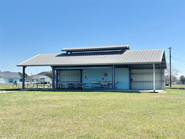 rear view of property with a yard and metal roof
